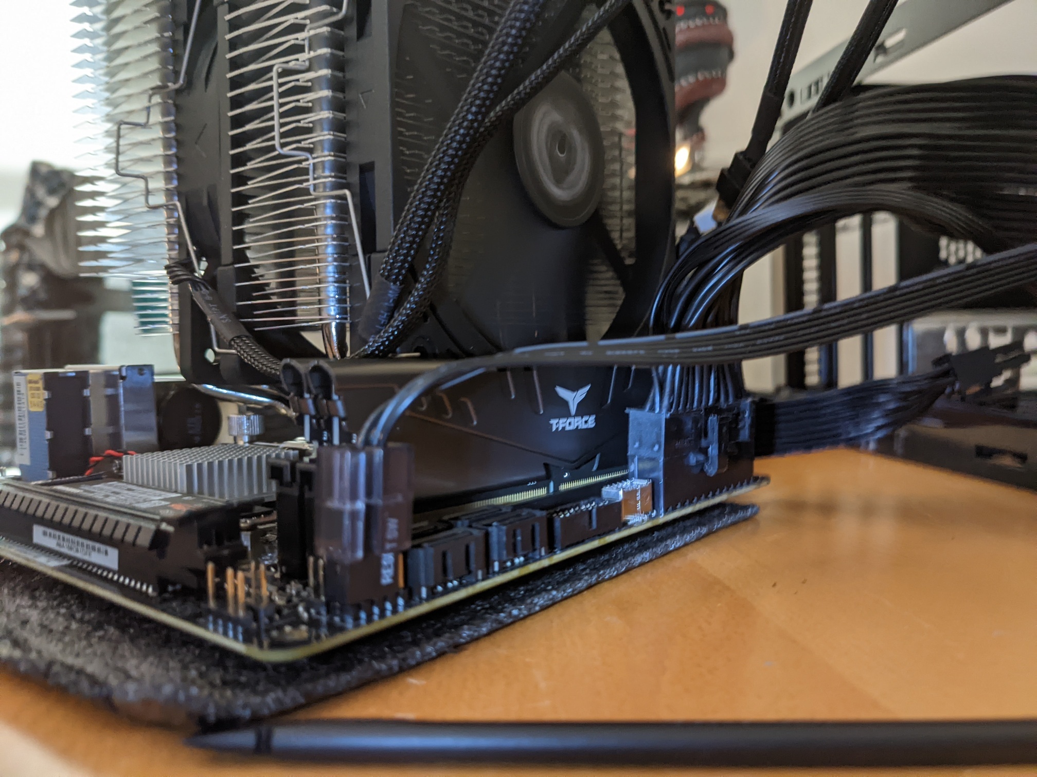A half-assembled motherboard with a cooler and some RAM sticks and cables.