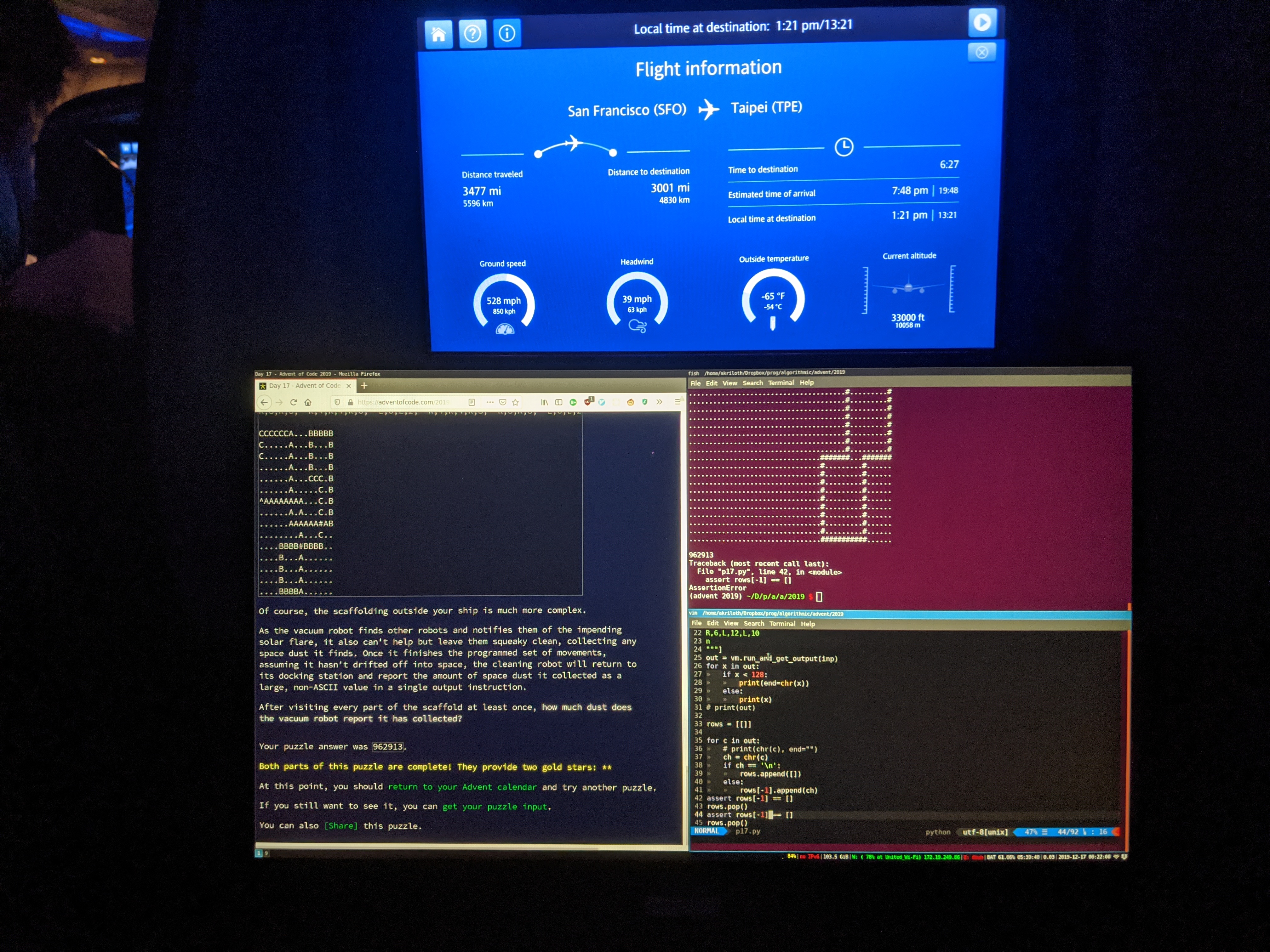 Photo of laptop with Advent of Code solution beneath an airplane monitor