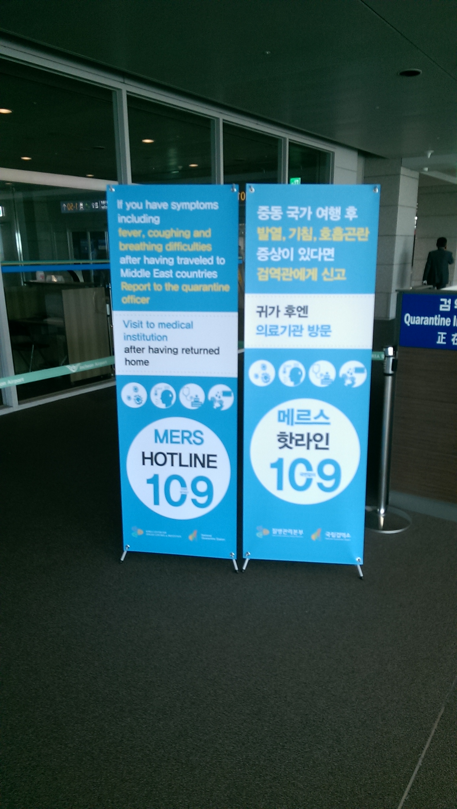 [Signs informing travelers about MERS in English and Korean]