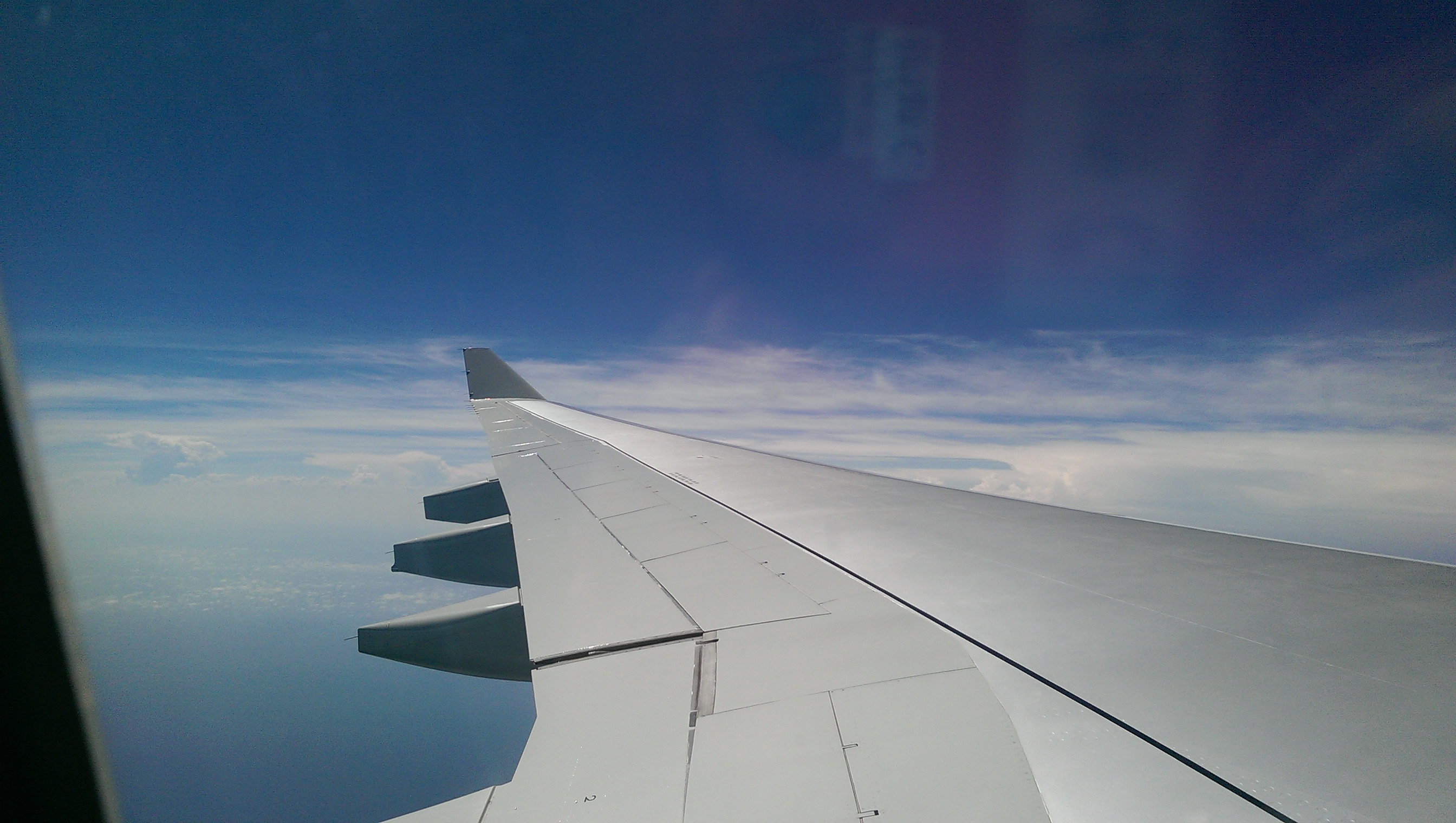 [View of airplane wing and clouds from airplane]